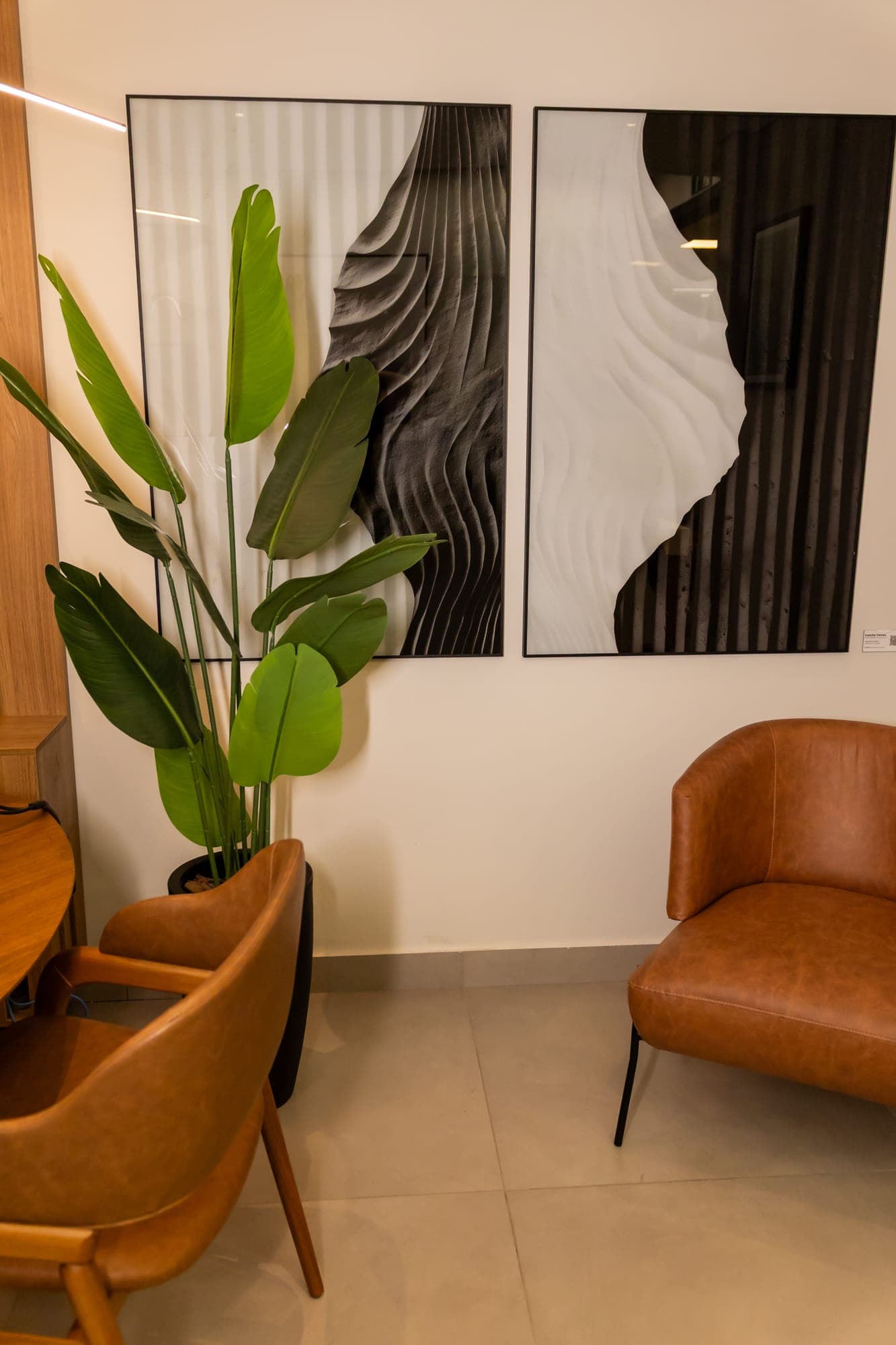 Lounge com poltronas e obras de arte